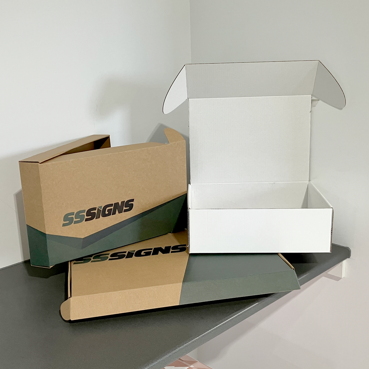 Customizable brown and white self-locking mailer boxes with the brand name 'SSigns' printed on them.