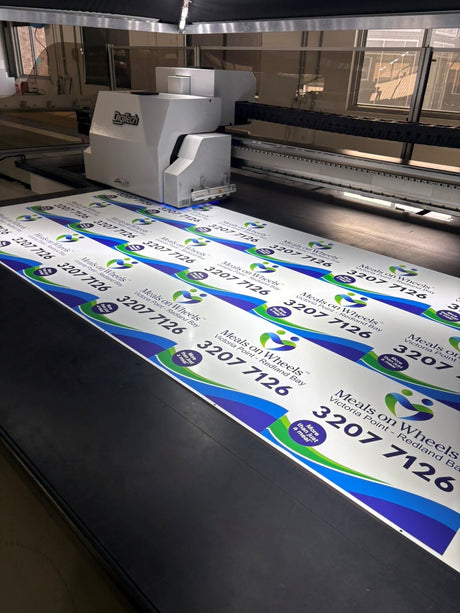 Large format printer with direct print to magnet featuring contact information on a flat surface.